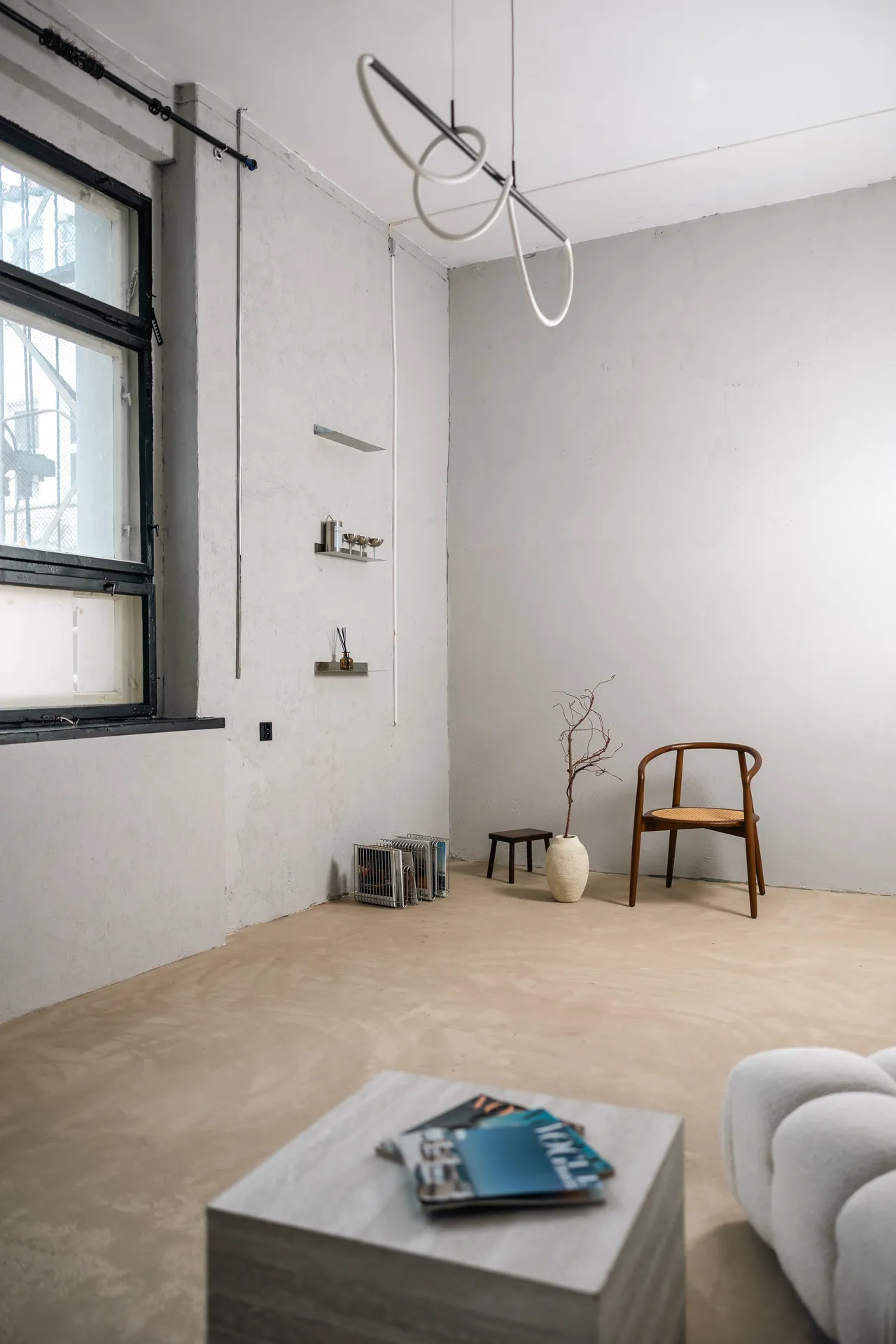Content Room, panorama pokoju z designerską lampą i krzesłem rattanowym